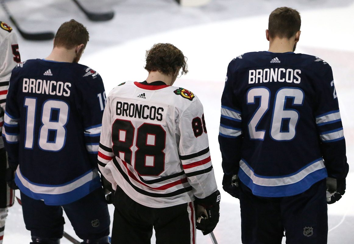 Bryan Little #18 and Blake Wheeler #26 of the Winnipeg Jets and Patrick Kane #88 of the Chicago Blackhawks honour those involved in the Humboldt Broncos bus crash tragedy before NHL action on April 7, 2018 at Bell MTS Place in Winnipeg, Manitoba. (Photo by Jason Halstead /Getty Images)