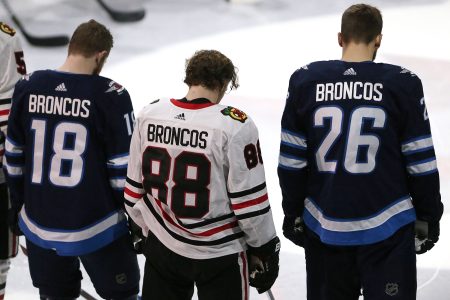Bryan Little #18 and Blake Wheeler #26 of the Winnipeg Jets and Patrick Kane #88 of the Chicago Blackhawks honour those involved in the Humboldt Broncos bus crash tragedy before NHL action on April 7, 2018 at Bell MTS Place in Winnipeg, Manitoba. (Photo by Jason Halstead /Getty Images)