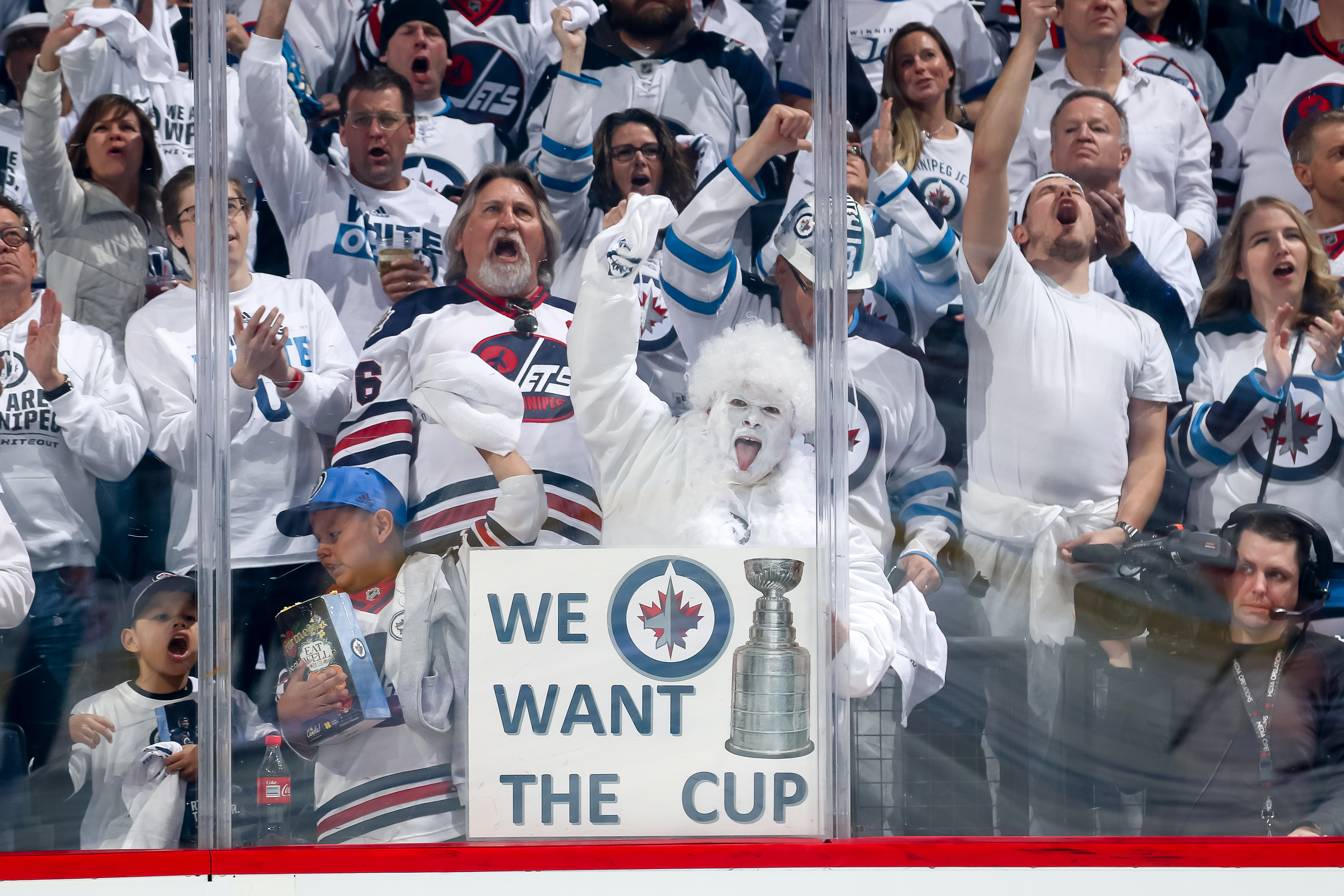 Winnipeg Jets fans clad in all white cheer wildly prior to NHL action between the Jets and the Minnesota Wild in Game Five of the Western Conference First Round during the 2018 NHL Stanley Cup Playoffs at the Bell MTS Place on April 20, 2018 in Winnipeg, Manitoba, Canada. (Photo by Jonathan Kozub/NHLI via Getty Images)