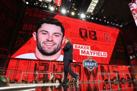 NFL Commissioner Roger Goodell walks past a video board displaying an image of Baker Mayfield of Oklahoma after he was picked #1 overall by the Cleveland Browns during the first round of the 2018 NFL Draft at AT&T Stadium on April 26, 2018 in Arlington, Texas.  (Photo by Ronald Martinez/Getty Images)