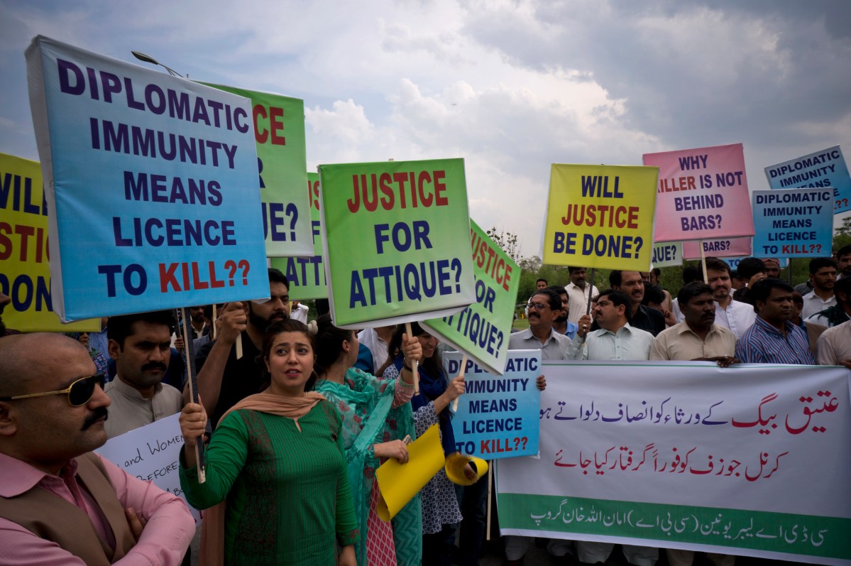 Pakistani protesters stage a rally demanding a trial for American diplomat involved in a vehicle crash that killed a person, in Islamabad, Pakistan, Tuesday, April 10, 2018. Police have requested the government impose a travel ban on an American diplomat involved in a vehicle crash over the weekend that killed one Pakistani man and injured another in the capital Islamabad. Banner reads "give justice to the family of Ateeq Baig, arrest Col. Joseph." (AP Photo/B.K. Bangash)