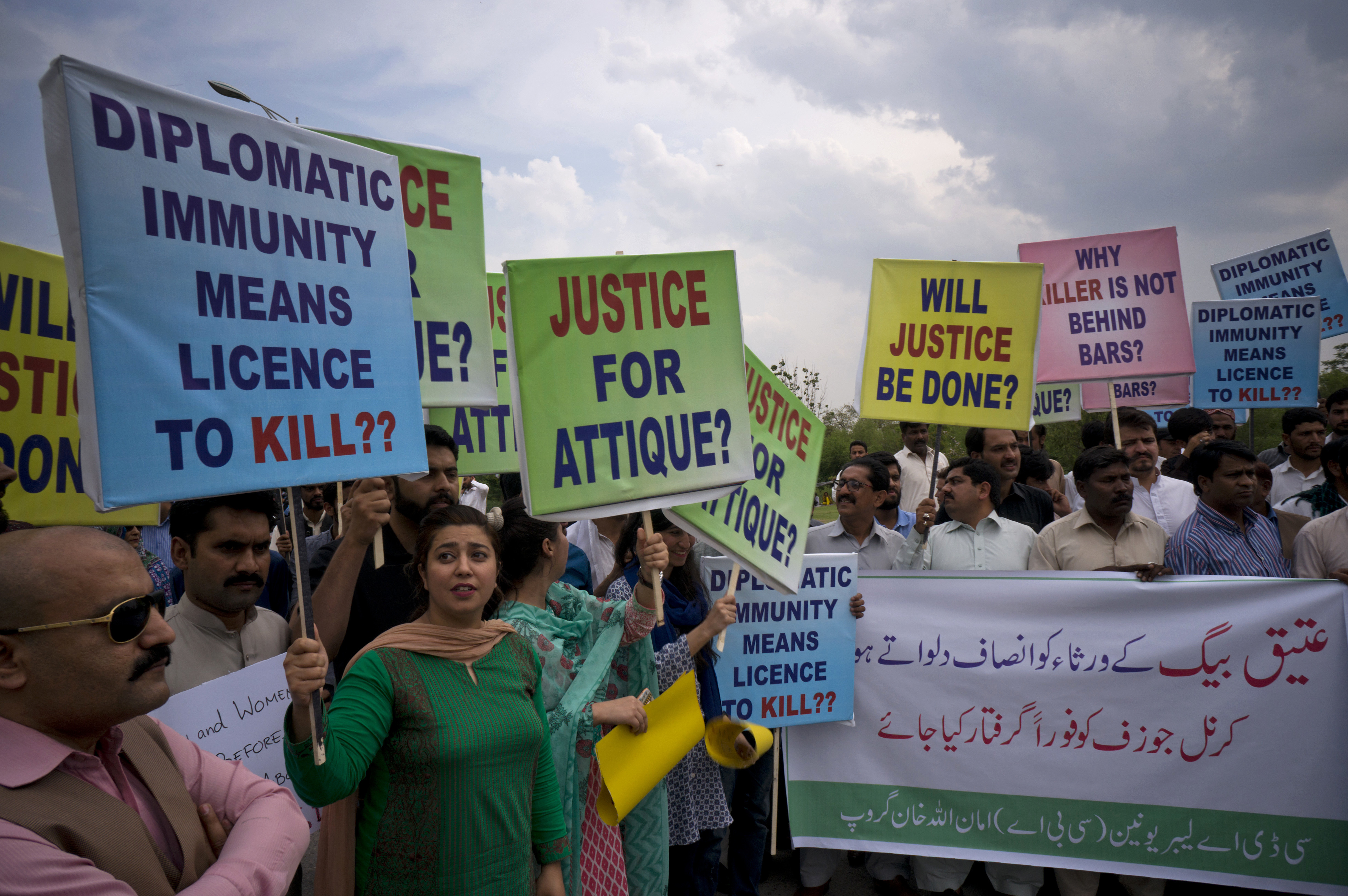Pakistani protesters stage a rally demanding a trial for American diplomat involved in a vehicle crash that killed a person, in Islamabad, Pakistan, Tuesday, April 10, 2018. Police have requested the government impose a travel ban on an American diplomat involved in a vehicle crash over the weekend that killed one Pakistani man and injured another in the capital Islamabad. Banner reads "give justice to the family of Ateeq Baig, arrest Col. Joseph." (AP Photo/B.K. Bangash)