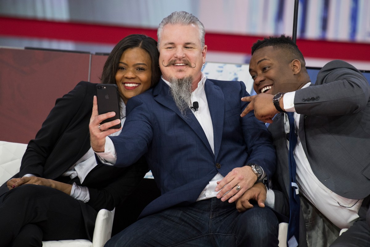 From left, Candace Owens, Chris Loesch, and Lawrence Jones III, take a selfie on stage at the Conservative Political Action Conference at the Gaylord National Resort in Oxon Hill, Md., on February 22, 2018. (Photo By Tom Williams/CQ Roll Call)