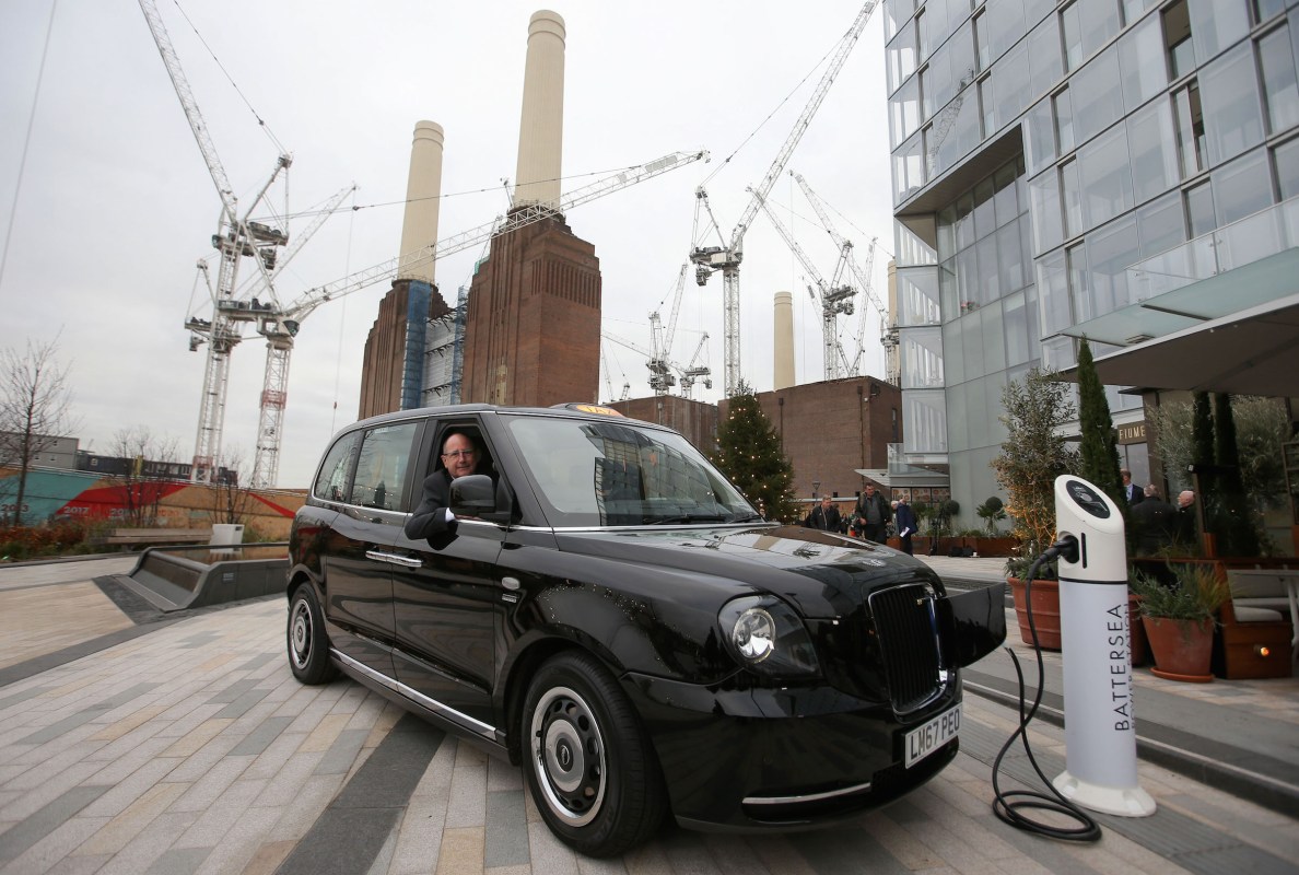CEO of London EV Company, Chris Gubbey poses inside the new electric TX eCity taxi connected to a sample electric vehicle charger at the Battersea power station in London on December 5, 2017.
London's first electric-powered black cabs hit the streets on December 5, 2017, the British capital's iconic taxis getting a facelift for the modern age that should help cut pollution in the city. / AFP PHOTO / Daniel LEAL-OLIVAS        (Photo credit should read DANIEL LEAL-OLIVAS/AFP/Getty Images)