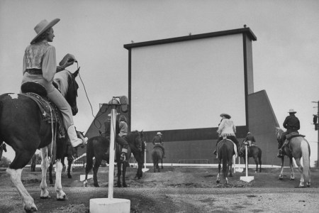 Horseback riders in cowboy garb, taking positions at speaker posts while settling in to watch the evening's feature at a Drive-In movie theater.  (Photo by Carl Iwasaki/The LIFE Images Collection/Getty Images)