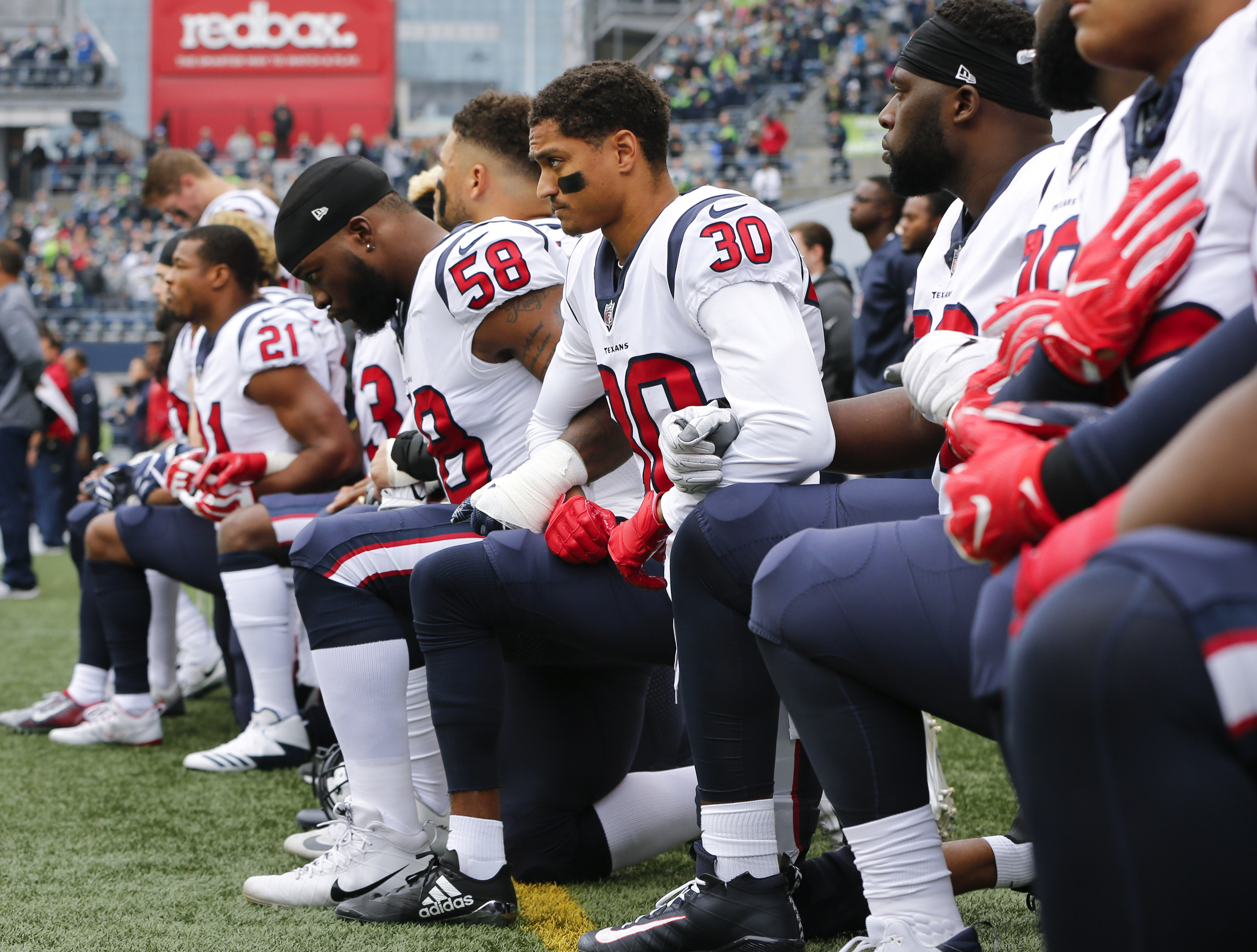 Members of the Houston Texans, including Kevin Johnson #30 and Lamarr Houston #58, kneel during the national anthem before the game at CenturyLink Field on October 29, 2017 in Seattle, Washington. (Jonathan Ferrey/Getty Images)