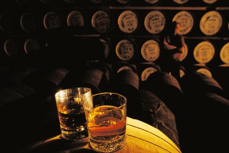 Whiskey glasses on a barrel in a whiskey distillery, Hebrides, United Kingdom.