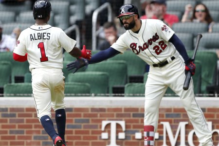 Ozzie Albies #1 of the Atlanta Braves is congratulated by Nick Markakis #22 after Albies scored in the ninth inning during the game against  the Miami Marlins at SunTrust Park on May 20, 2018 in Atlanta, Georgia.  (Photo by Mike Zarrilli/Getty Images)