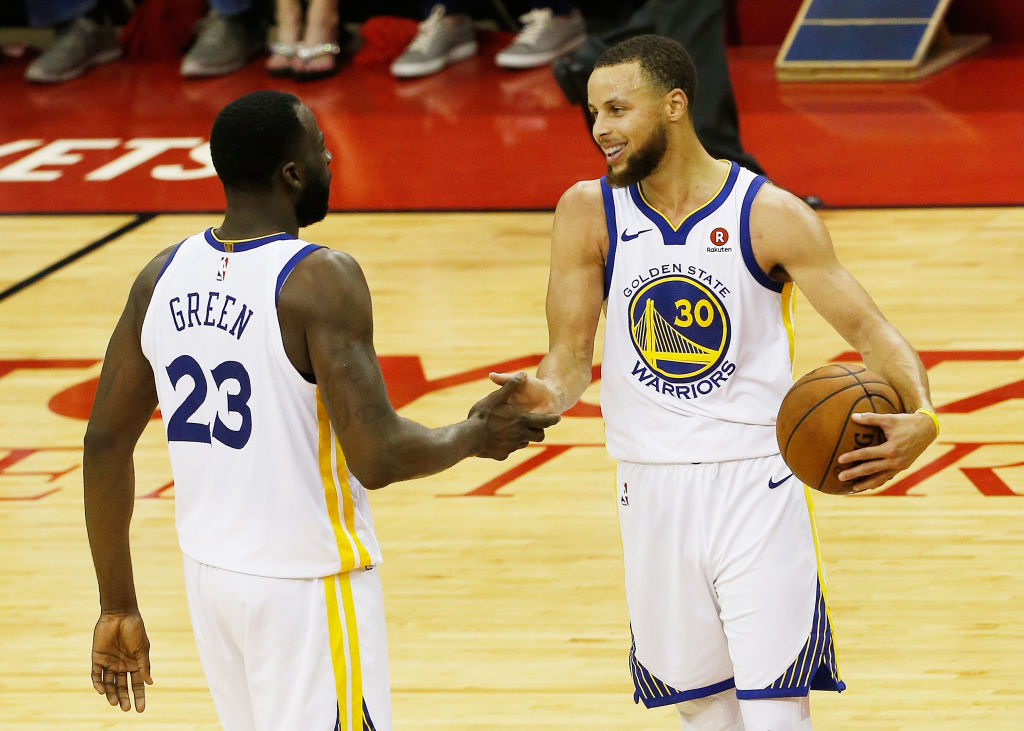 Stephen Curry #30 and Draymond Green #23 of the Golden State Warriors celebrate after they defeated the Houston Rockets 101 to 92 in Game Seven of the Western Conference Finals of the 2018 NBA Playoffs at Toyota Center on May 28, 2018 in Houston, Texas.(Photo by Bob Levey/Getty Images)