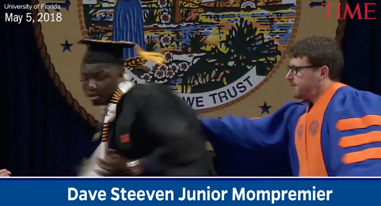 A screengrab from the commencement ceremony, in which a white faculty member rushed celebrating black students off the stage (Time)