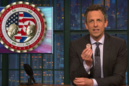 Seth Meyers holds up the now-defunct peace talks coin President Trump commissioned to be made for the North Korea talks (YouTube)