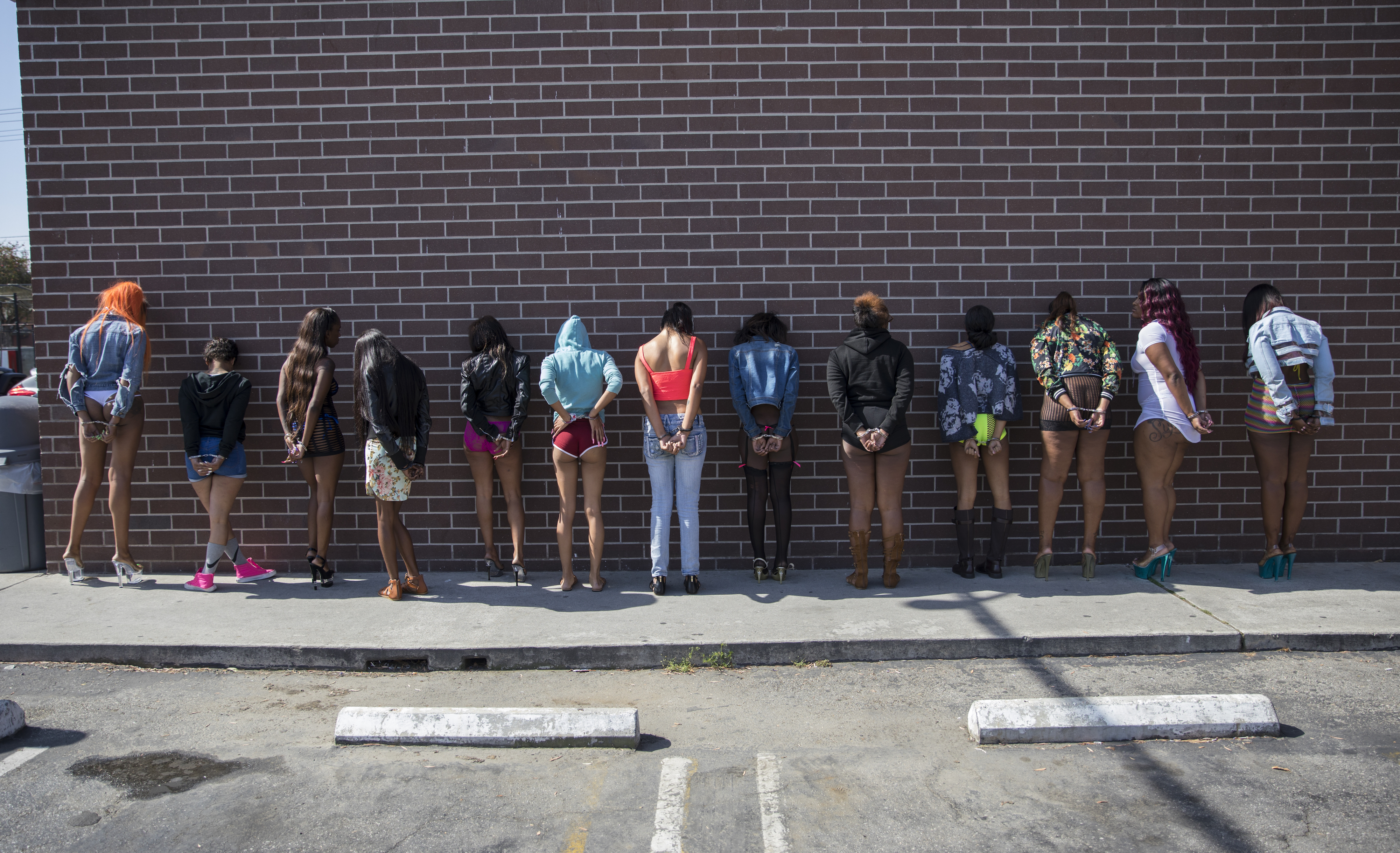 Officers of the  Los Angeles Police Department's vice squad prepare thirteen women for transportation after being arrested for prostitution May 18, 2017 in the southeast area of Los Angeles, California. (Robert Nickelsberg/Getty Images)