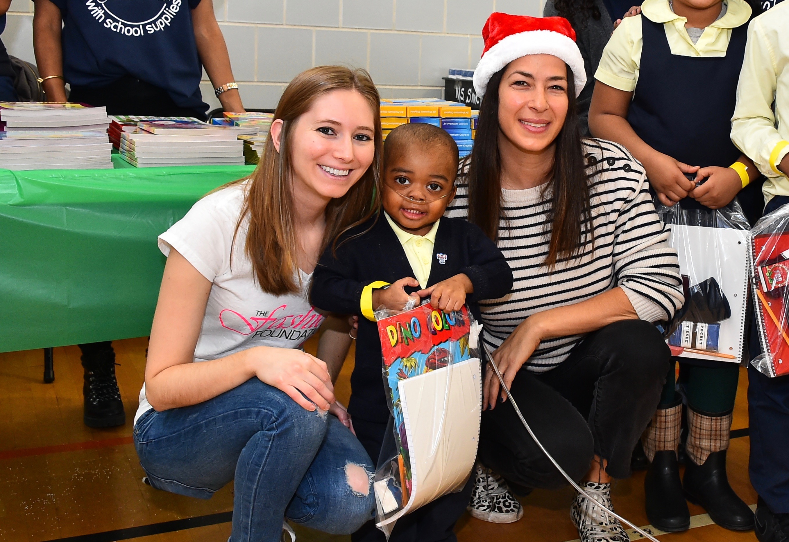 (L to R) The Fashion Foundation founder Amanda Munz, a student at a Brooklyn elementary school who received donated supplies and designer Rebecca Minkoff on December, 2016. (Courtesy of Amanda Munz)