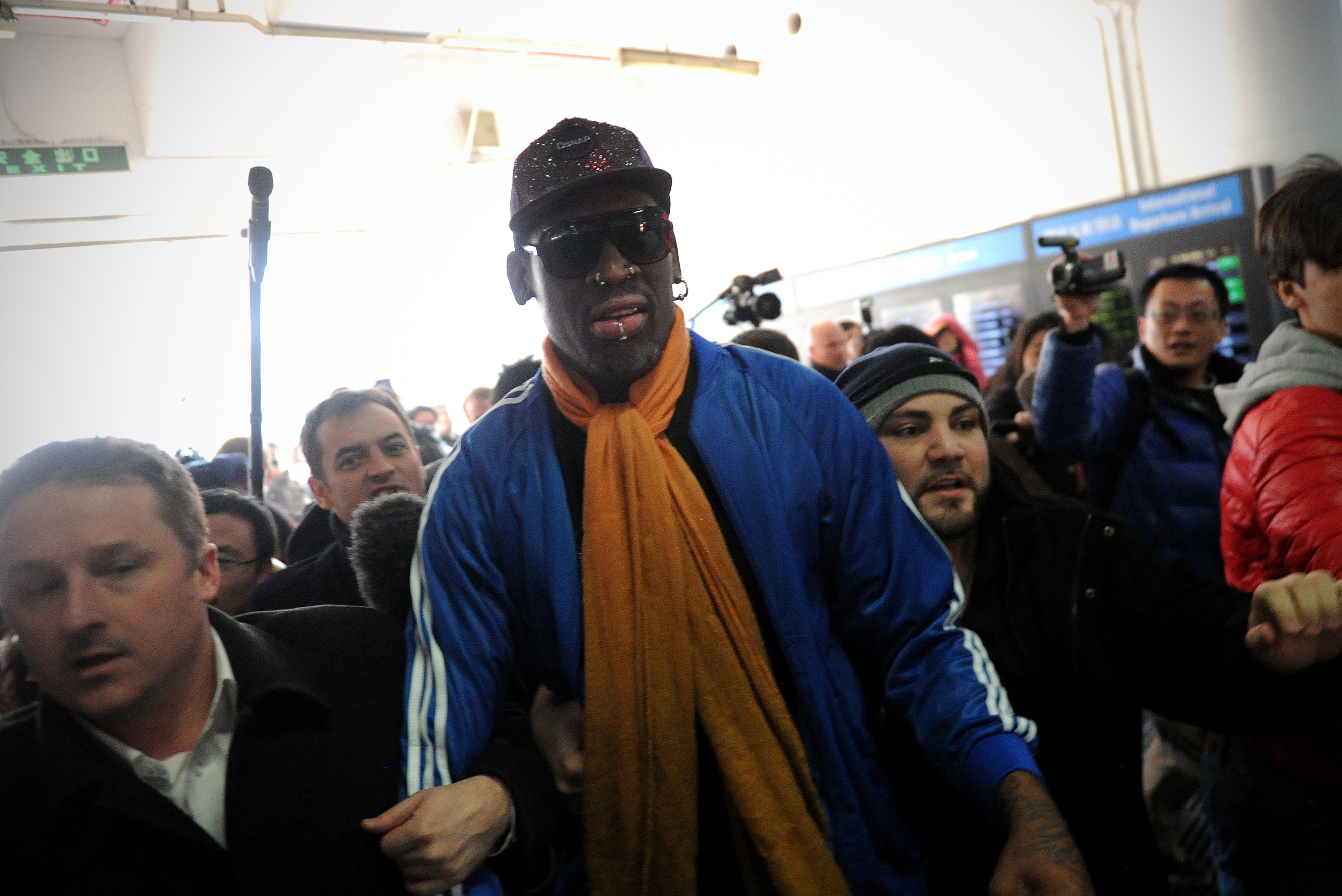 Former US basketball player Dennis Rodman (C) arrives at Beijing International Airport from North Korea on January 13, 2014.  Rodman returned to China from Pyongyang after a seven-day trip where he sang "Happy birthday to you!" to North Korean leader Kim Jong-Un on January 8. (WANG ZHAO/AFP/Getty Images)