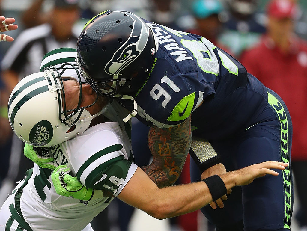 Cassius Marsh #91 of the Seattle Seahawks hits his helmet against quarterback Ryan Fitzpatrick #14 of the New York Jets for a penalty 'Roughing the Passer' in the second quarter at MetLife Stadium on October 2, 2016 in East Rutherford, New Jersey.  (Photo by Al Bello/Getty Images)