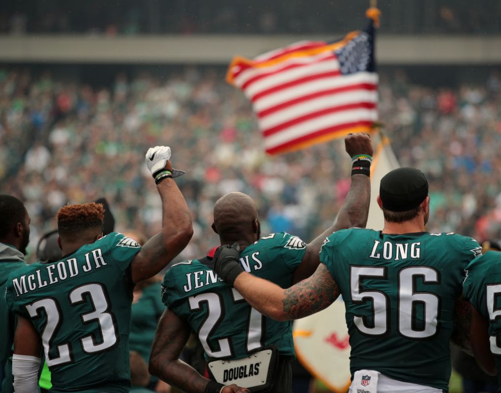 PHILADELPHIA, PA - OCTOBER 08: Rodney McLeod #23, Malcolm Jenkins #27 of the Philadelphia Eagles raise their fists in protest during the playing of the National Anthem as teammate Chris Long #56 shows support before a game against the Arizona Cardinals at Lincoln Financial Field on October 8, 2017 in Philadelphia, Pennsylvania. (Photo by Rich Schultz/Getty Images)