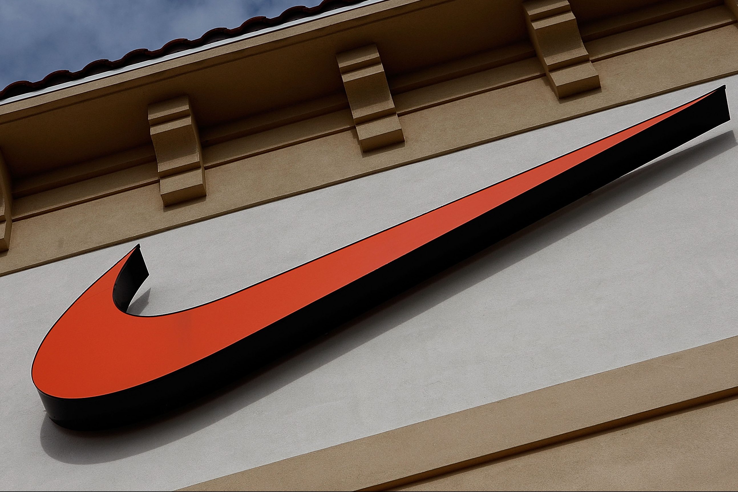 An orange Nike Swoosh logo on a Nike Factory store