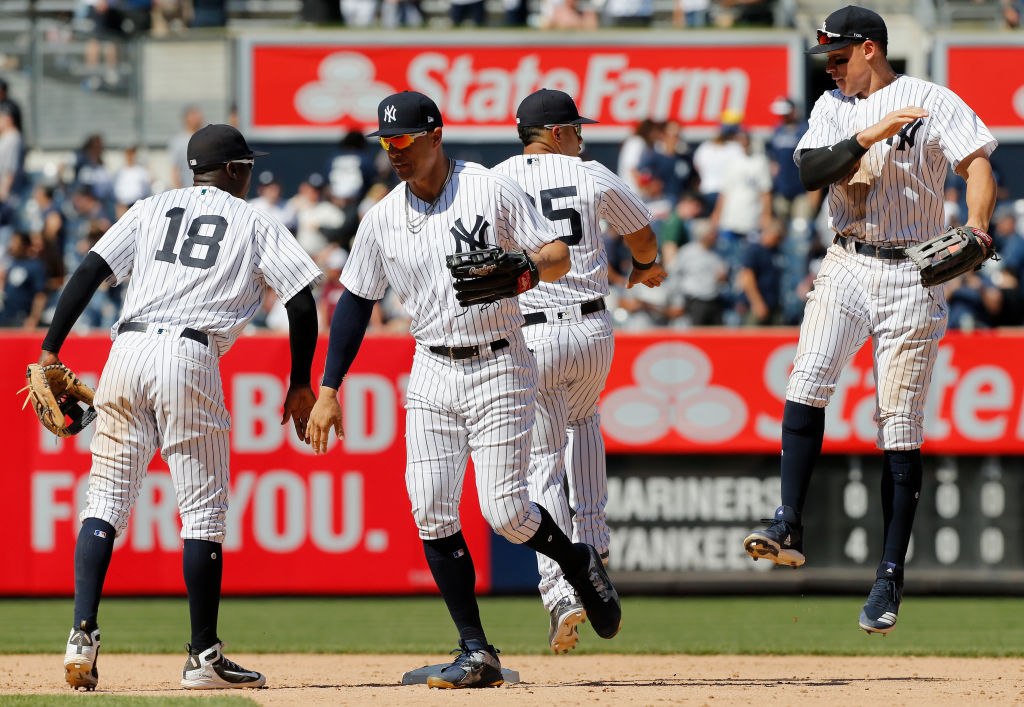 Didi Gregorius #18, Giancarlo Stanton #27, Gleyber Torres #25 and Aaron Judge #99 of the New York Yankees celebrate after defeating the Seattle Mariners at Yankee Stadium on June 21, 2018 in the Bronx borough of New York City. The Yankees defeated the Mariners 4-3.  (Photo by Jim McIsaac/Getty Images)