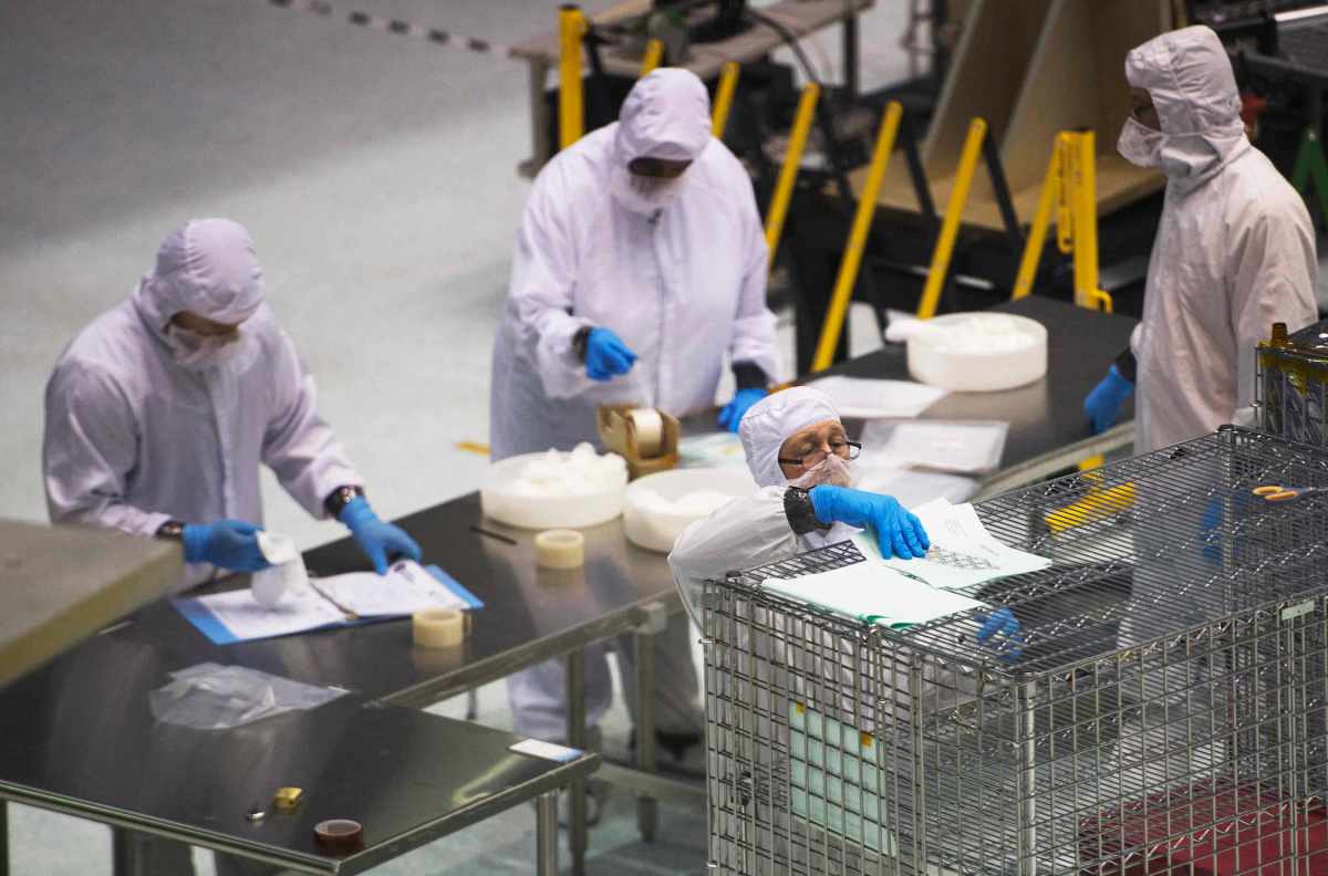 James Webb Space Telescope engineers and scientists work  in a clean room at the NASA Goddard Space Flight Center in Greenbelt, Maryland on April 2, 2015.   AFP PHOTO/ JIM WATSON (Photo by JIM WATSON / AFP)        (Photo credit should read JIM WATSON/AFP/Getty Images)