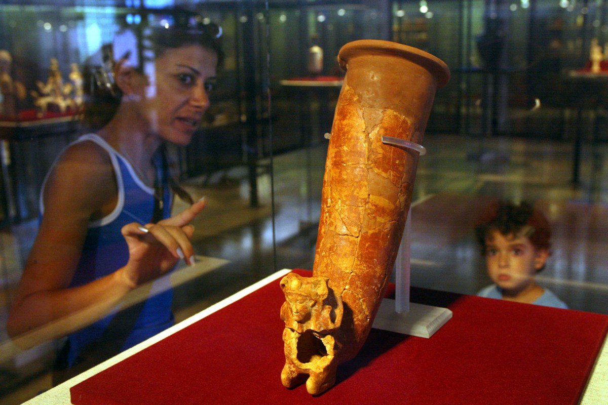Israeli mother, Sarit Meiri, explains to her five-year-old son, Tal, the Persian ceramic drinking horn, dated to the 5th century BC and excavated from the central Israeli site of Tel Ya'oz, on display at the Land of Israel Museum (Photo by David Silverman/Getty Images)