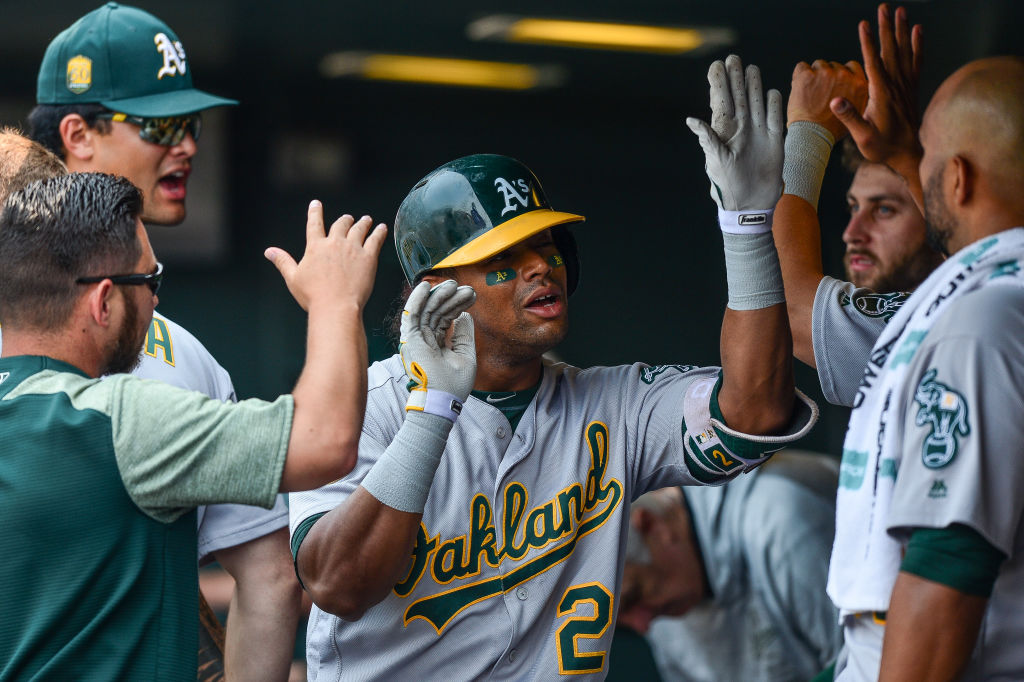Khris Davis #2 of the Oakland Athletics is congratulated in the dugout after hitting a seventh inning solo homerun against the Colorado Rockies during interleague play at Coors Field on July 29, 2018 in Denver, Colorado.  (Photo by Dustin Bradford/Getty Images)