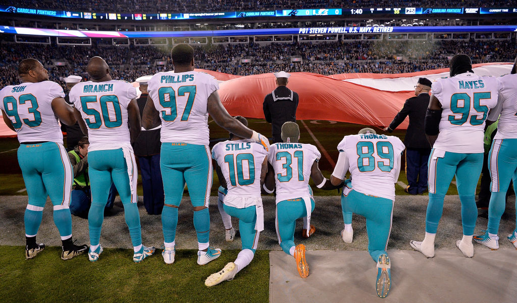 Miami Dolphins players kneel during the national anthem before their game against the Carolina Panthers at Bank of America Stadium on November 13, 2017 in Charlotte, North Carolina.  (Photo by Grant Halverson/Getty Images)