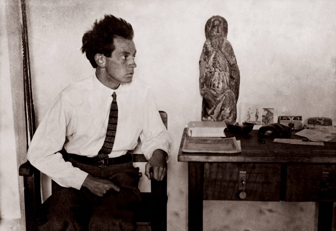 Egon Schiele with a Madonna figure in his studio in Vienna's 13th district. Photography, around 1915.