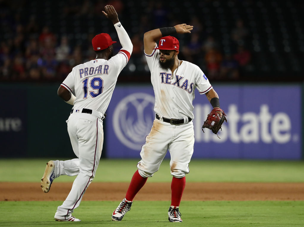 ARLINGTON, TX - AUGUST 16:  (L-R) Jurickson Profar #19 and Rougned Odor #12 of the Texas Rangers celebrate a triple play against the Los Angeles Angels in the fourth inning at Globe Life Park in Arlington on August 16, 2018 in Arlington, Texas.  (Photo by Ronald Martinez/Getty Images)