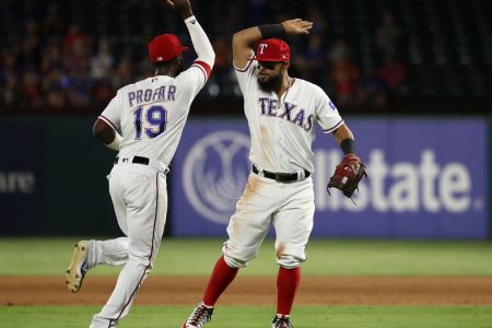 ARLINGTON, TX - AUGUST 16:  (L-R) Jurickson Profar #19 and Rougned Odor #12 of the Texas Rangers celebrate a triple play against the Los Angeles Angels in the fourth inning at Globe Life Park in Arlington on August 16, 2018 in Arlington, Texas.  (Photo by Ronald Martinez/Getty Images)