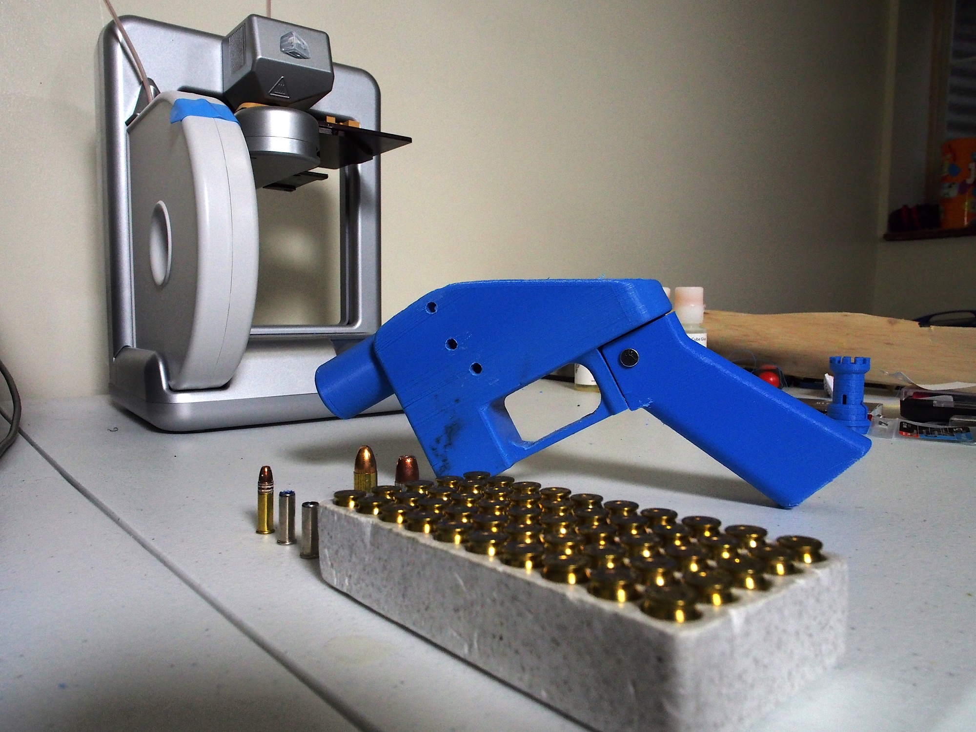 A Liberator pistol appears on July 11, 2013 next to the 3D printer on which its components were made. The single-shot handgun is the first firearm that can be made entirely with plastic components forged with a 3D printer and computer-aided design (CAD) files downloaded from the Internet. (Robert MacPherson/AFP/Getty Images)
