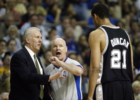 AUBURN HILLS, UNITED STATES:  Tim Duncan (R) of the San Antonio Spurs tries to talk with offical Joe Crawford (C) as head coach Gregg Popovich (L) listens during their game against the Detroit Pistons during the first half of game three of the NBA Finals 14 June, 2005 at The Palace in Auburn Hill, Michigan. (JEFF HAYNES/AFP/Getty Images)