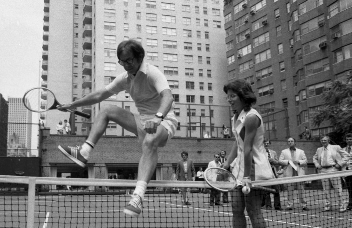 [Original caption] Wimbledon whiz Billie Jean King is glad to lend a hand to a doddering 55-year-old-Bobby Riggs as he hops over net at E. 56th St. court. Bobby and Billie have a date for a $100,000 match one of these days and it's made more interesting in that Billie seems to think Bobby might be some kind of male chauvinist. (Jim Garrett/NY Daily News via Getty Images)