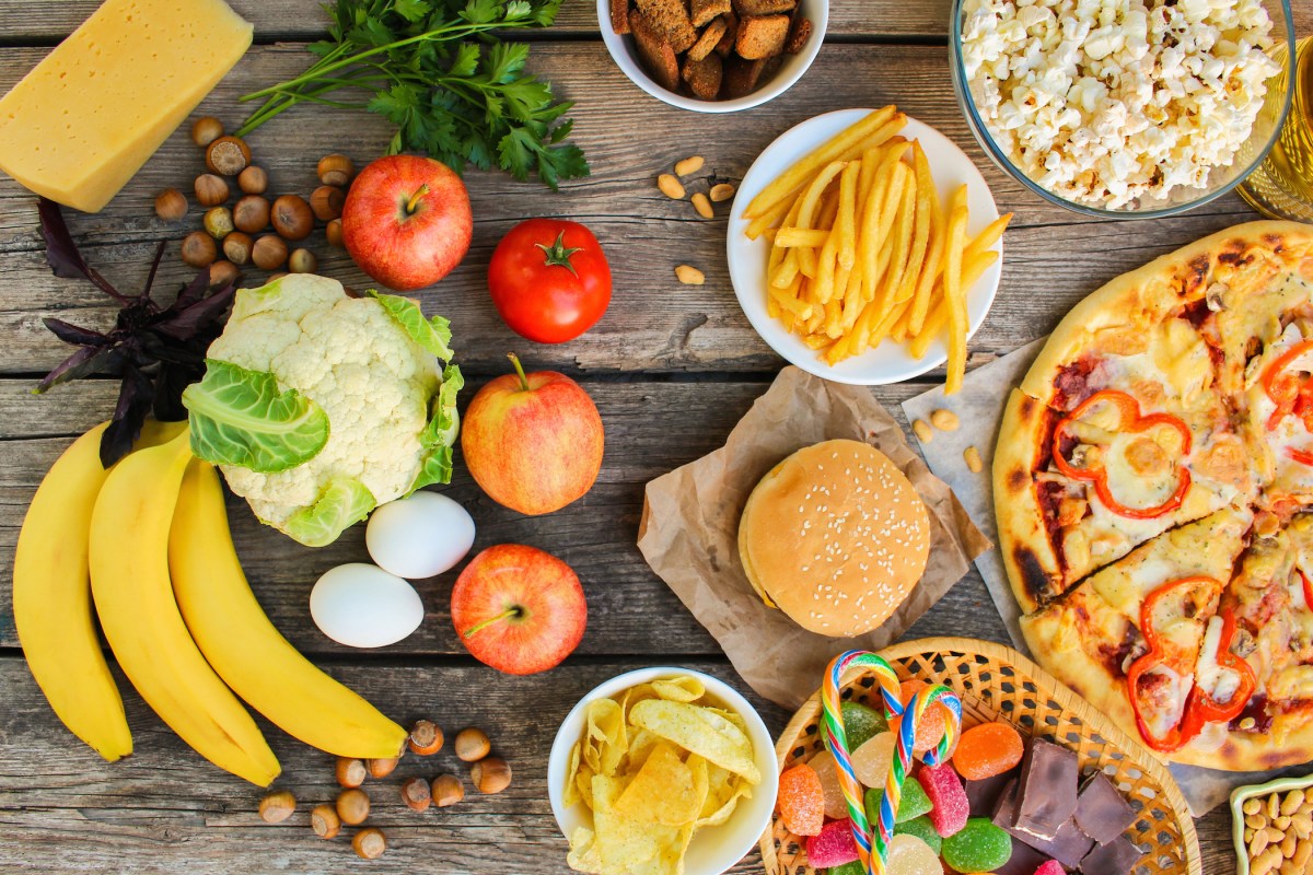 Fastfood and healthy food on old wooden background. A recent study found that high-fat foods are a more significant cause of obesity than sugars. Photo by 	Mukhina1/iStock/Getty Images Plus)