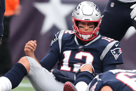 New England Patriots quarterback Tom Brady sits on the field after being sacked during a game against the Houston Texans. (Photo by Jim Davis/The Boston Globe via Getty Images)