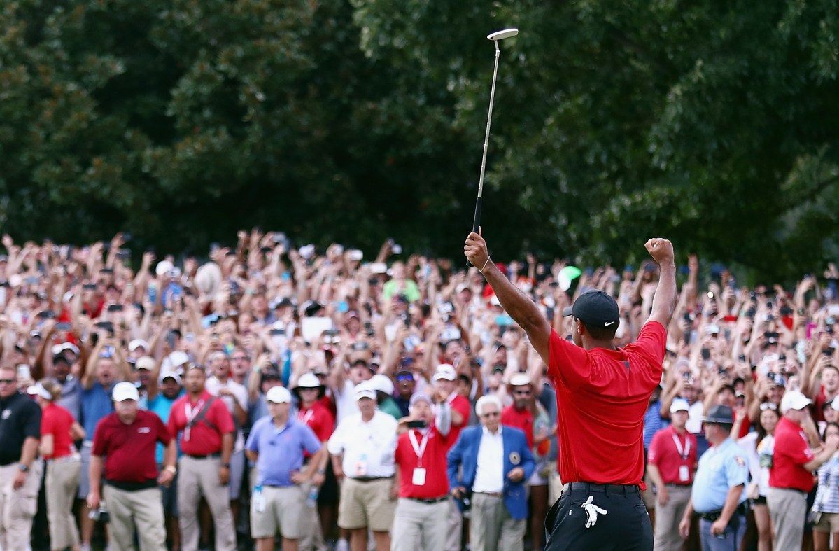 Tiger Woods of the United States celebrates making a par on the 18th green to win the TOUR Championship at East Lake Golf Club on September 23, 2018 in Atlanta, Georgia. With the victory, Woods secured his 80th PGA tour victory.  (Photo by Tim Bradbury/Getty Images)