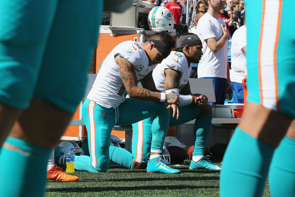 FOXBOROUGH, MA - SEPTEMBER 30:  Kenny Stills #10 and Albert Wilson #15 of the Miami Dolphins kneel during the national anthem prior to their game against the New England Patriots at Gillette Stadium on September 30, 2018 in Foxborough, Massachusetts.  (Photo by Jim Rogash/Getty Images)