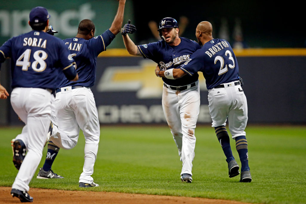 MILWAUKEE, WI - OCTOBER 4:  Mike Moustakas #18 of the Milwaukee Brewers celebrates with teammates after hitting the game-winning RBI single in the ninth inning to beat the Colorado Rockies in Game 1 of the NLDS at Miller Park on Thursday, October 4, 2018 in Milwaukee, Wisconsin. (Photo by Mike McGinnis/MLB Photos via Getty Images)