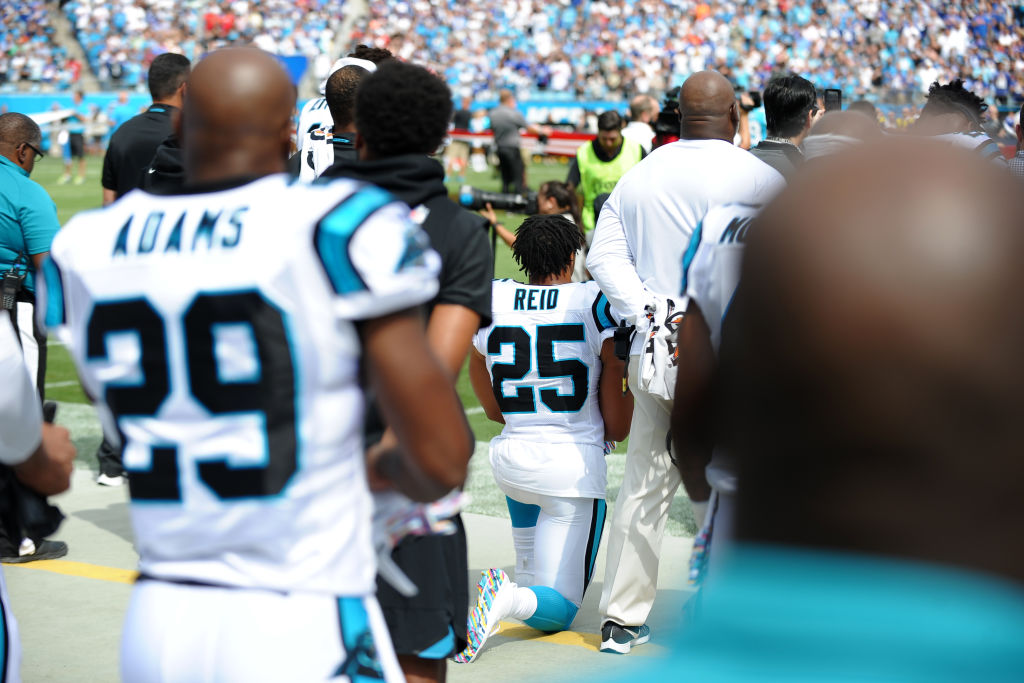 Carolina Panthers players try to block the view of Carolina Panthers safety Eric Reid (25) taking a knee during the National Anthem in his first game with the team prior to the NFL game between the New York Giants and the Carolina Panthers on October 07, 2018 at Bank of America Stadium in Charlotte,NC. (Photo by Dannie Walls/Icon Sportswire via Getty Images)