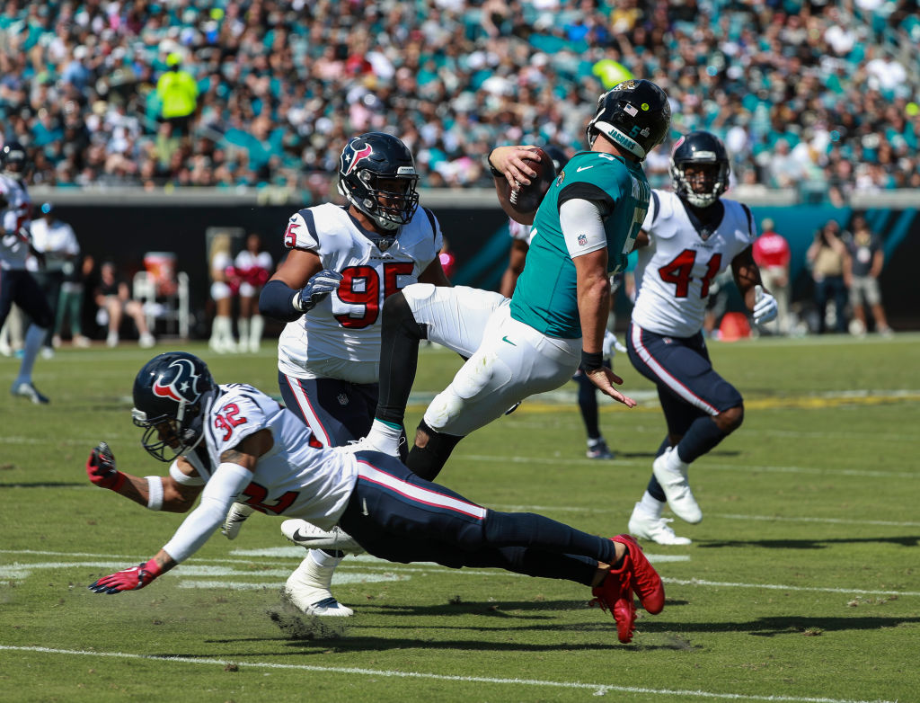 Blake Bortles #5 of the Jacksonville Jaguars is brought down by members of the Houston Texans defense during the second half at TIAA Bank Field on October 21, 2018 in Jacksonville, Florida.  (Photo by Scott Halleran/Getty Images)