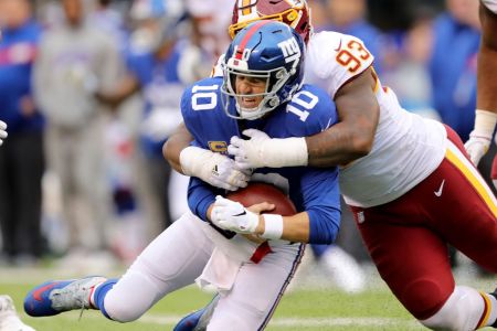 Eli Manning #10 of the New York Giants is sacked by Jonathan Allen #93 of the Washington Redskins on October 28,2018 at MetLife Stadium in East Rutherford, New Jersey.  (Photo by Elsa/Getty Images)