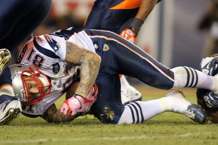 DENVER, CO - DECEMBER 18: Chris Harris #25 of the Denver Broncos tackles Aaron Hernandez #81 of the New England Patriots on December 18, 2011 during the second half at Sports Authority Field at Mile High in Denver, Colorado. (Photo by Marc Piscotty/Getty Images)
