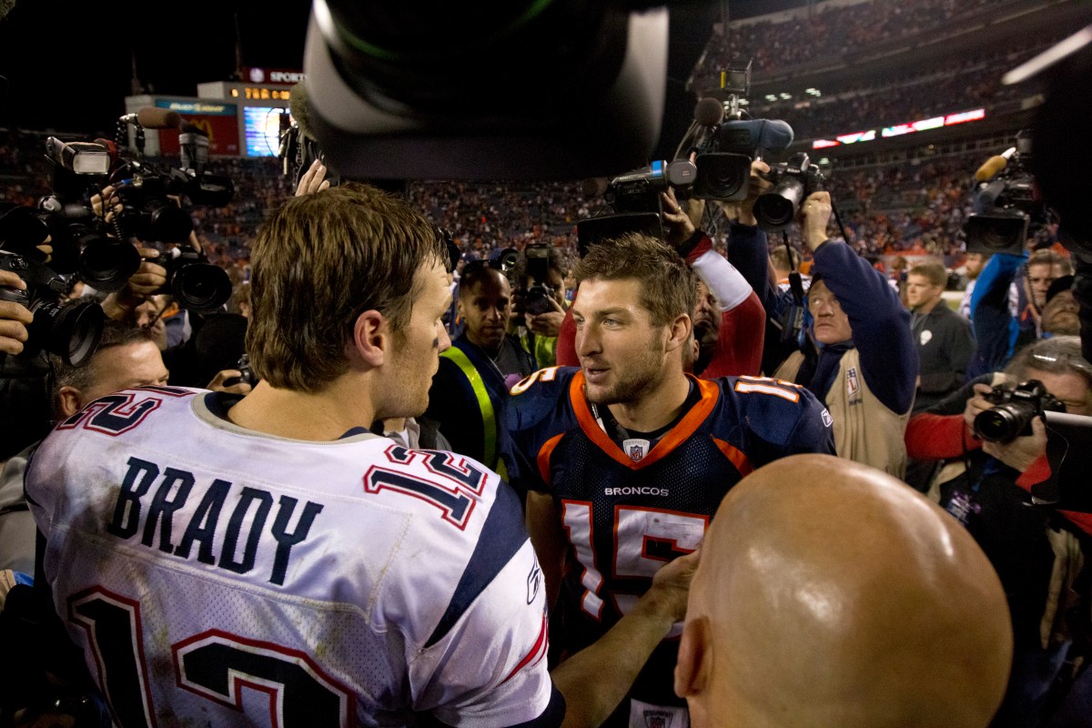 New England Patriots Tom Brady and Denver Broncos Tim Tebow meet after the Patriots defeated the Broncos 41-23 at Sports Authority Field on Sunday, Dec. 18, 2011. (Photo by Matthew J. Lee/The Boston Globe via Getty Images)