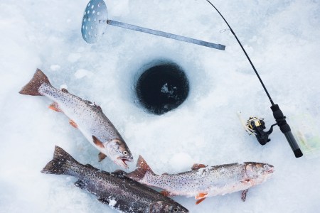 Ice fishing hole, fishing rods and trout. Stock photo. (Getty)