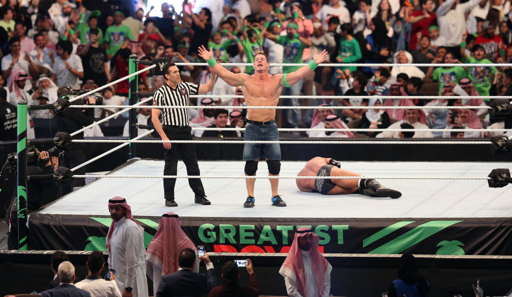 John Cena (C) celebrates defeating Triple H (R) during the World Wrestling Entertainment (WWE) Greatest Royal Rumble event in the Saudi coastal city of Jeddah on April 27, 2018. (Photo by STRINGER / AFP) 