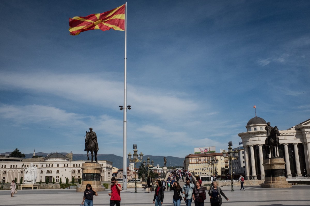 People walk under a larg Macedonian flag on September 28, 2018 in Skopje, Macedonia. Macedonians will go to the polls Sunday to vote in a referendum to change the countries name to the "Republic of North Macedonia" and end a long running dispute with Greece. Macedonia would not be the first country in recent memory to change its name. (Photo by Chris McGrath/Getty Images)