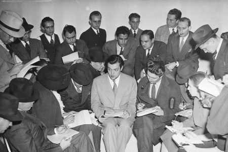 [Original caption] Actor Orson Welles explains the radio broadcast of H.G. Wells' 'The War of the Worlds' to reporters after it caused widespread panic. (Getty Images)