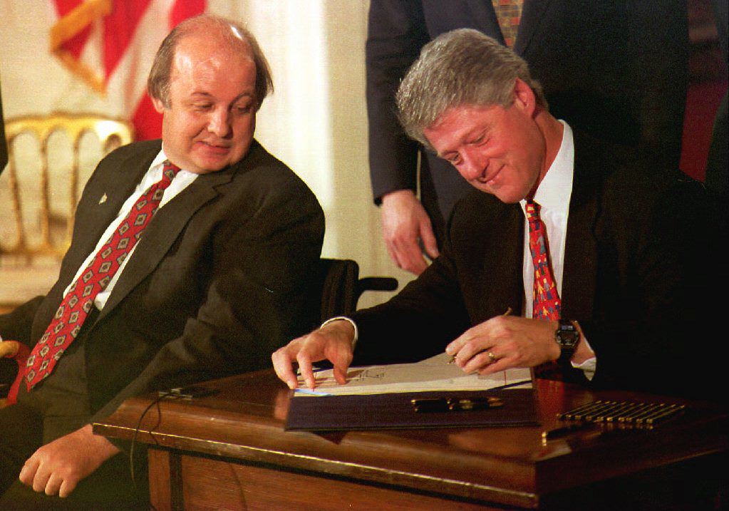 WASHINGTON, DC - NOVEMBER 30:  James Brady (L), the Reagan Administration press secretary who was wounded during the 1981 attempted assassination of then President Ronald Reagan, watches as U.S. President Bill Clinton signs the Brady Bill at the White House 30 November 1993. (PAUL RICHARDS/AFP/Getty Images)
