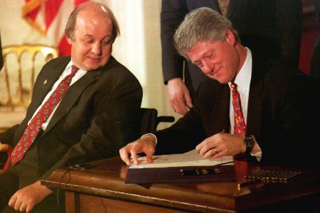 WASHINGTON, DC - NOVEMBER 30:  James Brady (L), the Reagan Administration press secretary who was wounded during the 1981 attempted assassination of then President Ronald Reagan, watches as U.S. President Bill Clinton signs the Brady Bill at the White House 30 November 1993. (PAUL RICHARDS/AFP/Getty Images)