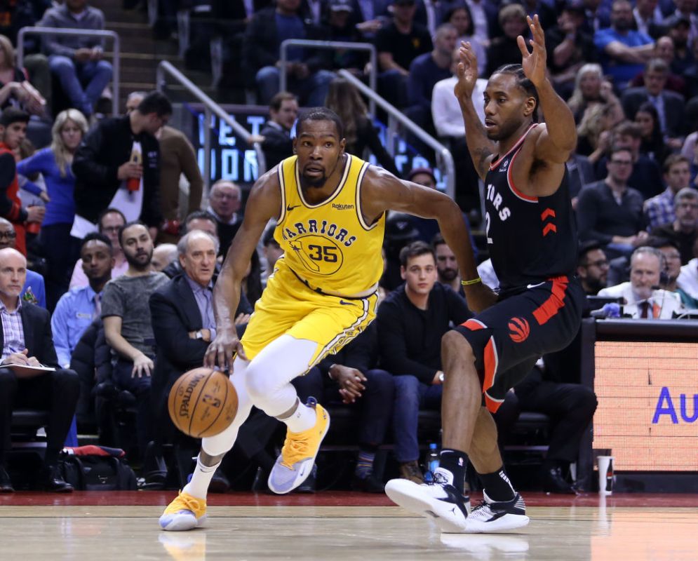 TORONTO, ON - NOVEMBER 29:  Kevin Durant #35 of the Golden State Warriors dribbles the ball as Kawhi Leonard #2 of the Toronto Raptors defends during the second half of an NBA game at Scotiabank Arena on November 29, 2018 in Toronto, Canada. (Photo by Vaughn Ridley/Getty Images)