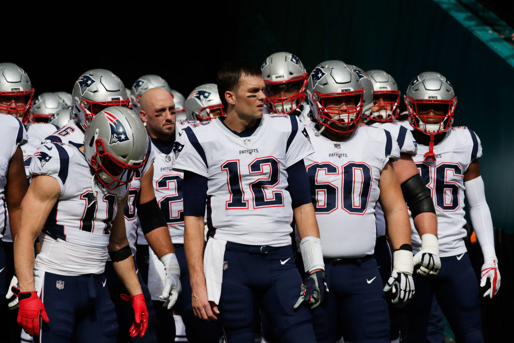 Tom Brady #12 of the New England Patriots and teammates prepare to take the field for their game against the Miami Dolphins at Hard Rock Stadium on December 9, 2018 in Miami, Florida.  (Photo by Cliff Hawkins/Getty Images)